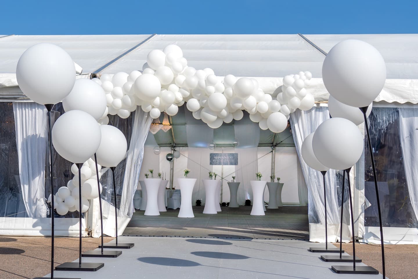 Entré med vita ballonger och tält inför Brandt White Party.